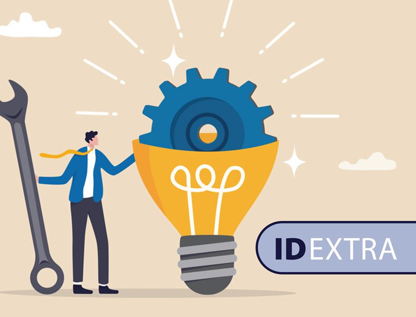 Illustration of a businessman holding a wrench next to a large gear coming out of the top of a lightbukb