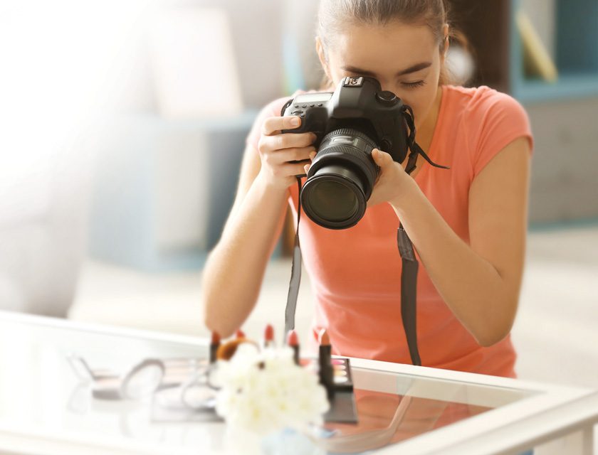 woman photographing products on a glass table