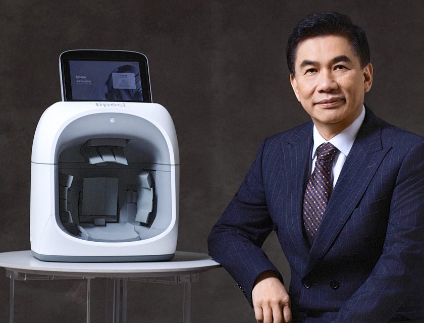 Inventor Shih Mo seated beside the Tiposi microwave brain imaging device designed to detect stroke rapidly.