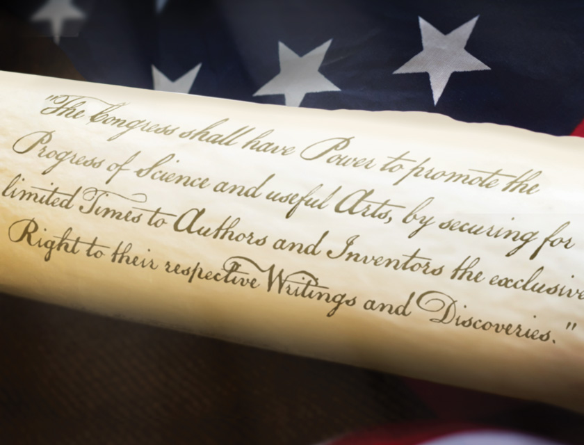 Article 1, Section 8 of the U.S. Constitution describing Congress' power to protect inventors and authors, displayed in front of an American flag.